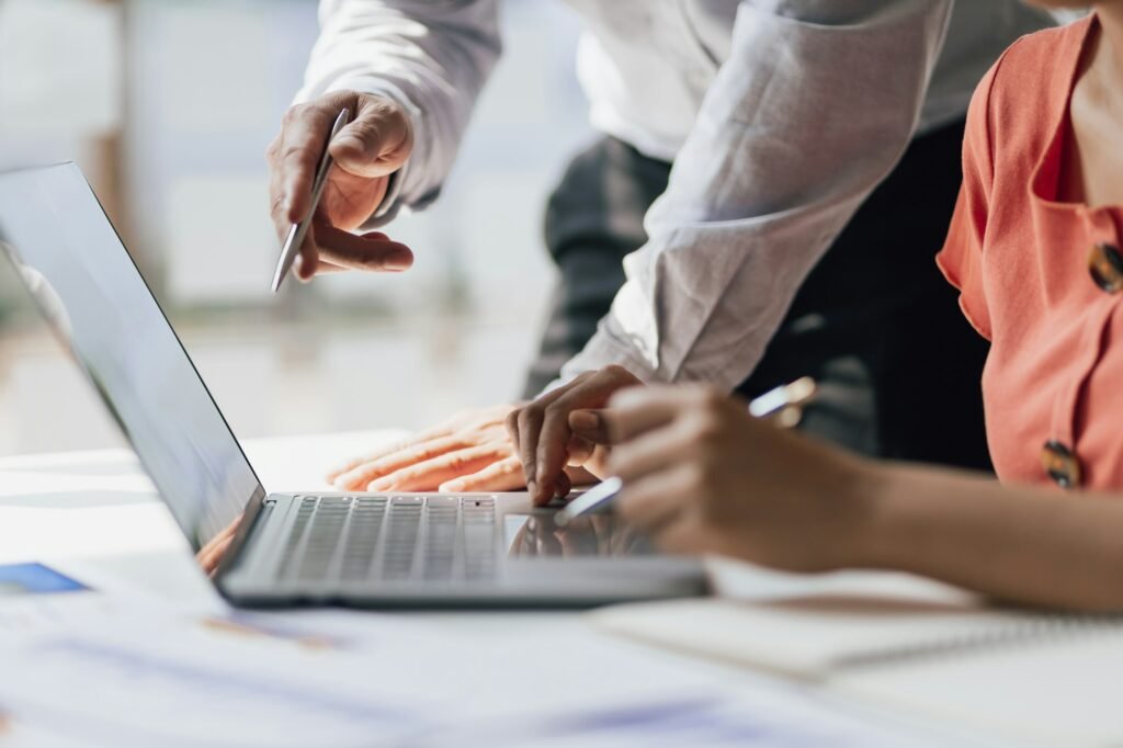 Business accountants are coaching laptop-based apprentices on tax systems.